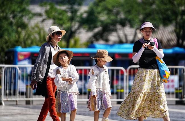 前门步行街游客“花式防晒” 抵御骄阳高温